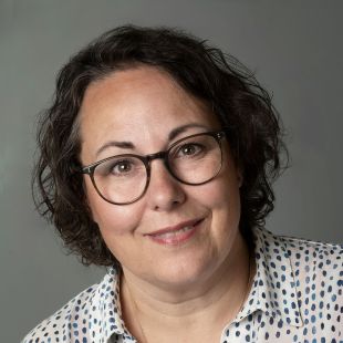 Rachel Walraven - vrouw met bril en donker licht krullend haar tot net boven de schouder